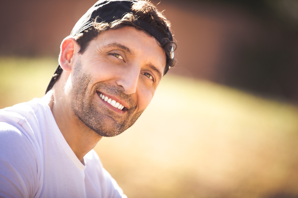 Man smiling in natural light symbolizing awareness of eye health and medical conditions explained by what are nerve palsies - what are nerve palsies